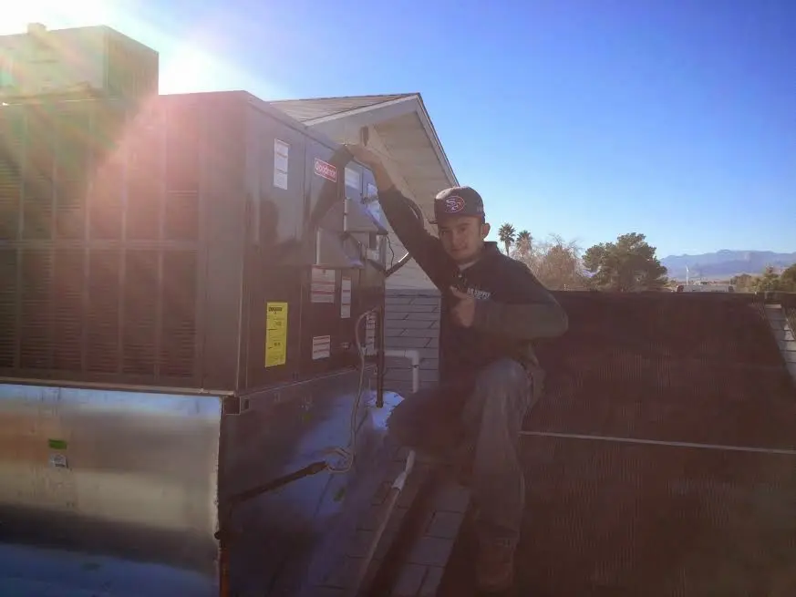 HVAC technician performing Heat Pump Repair on a rooftop unit in Pleasant Grove
